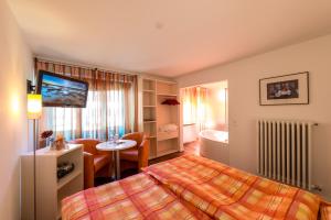 um quarto de hotel com uma cama e uma sala de estar em Hotel La Romantica em Le Prese, Poschiavo