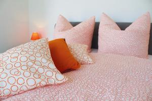ein Bett mit rosa und weißen Kissen darauf in der Unterkunft Severin Apartments in Severin
