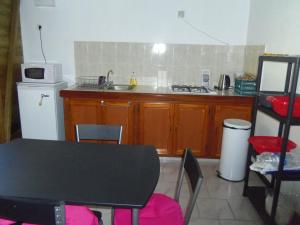 a kitchen with a table and a sink and a stove at La Belle Creole in Morne-à-lʼEau