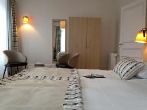 a bed room with a white bedspread and pillows at Hôtel De L'Europe in Morlaix