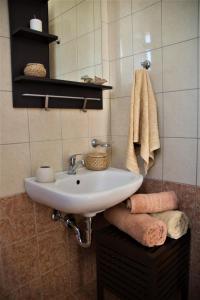 a bathroom with a white sink and towels at Casa Verde Houses in Kos Town