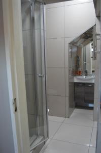 uma casa de banho com uma cabina de duche em vidro e um lavatório. em Shalimar B&B em Table View