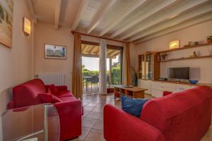 a living room with two red chairs and a television at Residence Corte Ferrari -Ciao Vacanze- in Moniga