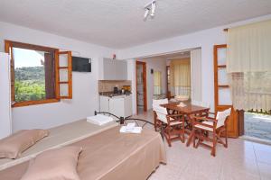 a bedroom with a bed and a table with chairs at Marlitsis Apartments & Studios in Skopelos Town