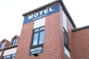 um sinal na lateral de um edifício de tijolos em Motel Schönefeld em Großziethen