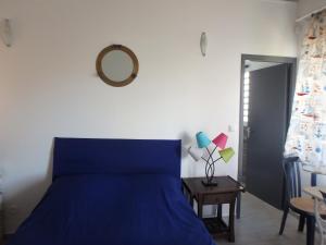 1 dormitorio con cama azul y mesa con espejo en La Marine, en Le Moule