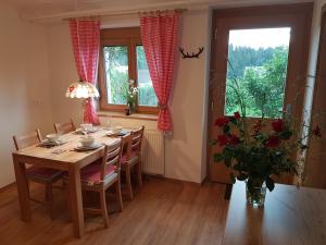 a dining room with a table and a vase of flowers at Apartment Eden Bled in Bled