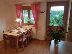 une salle à manger avec une table et un vase de fleurs dans l'établissement Apartment Eden Bled, à Bled