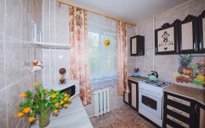 ヤロスラヴリにあるАпартаменты на улице Чкалова,82аのキッチン(シンク、コンロ付)、窓が備わります。