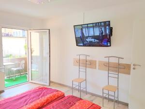 ニュルンベルクにあるApartment Reginaの壁にテレビとベッドが備わる客室です。