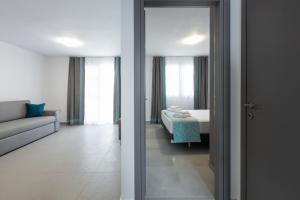 ネア・ポティダイアにあるSaint Lucas Suitesのベッド1台と鏡付きの客室の2つの景色を望めます。