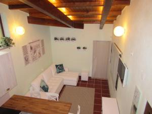 een woonkamer met een witte bank en een tv bij Quinta Sobral Prestige - Little Rustic in Sobral de Monte Agraço
