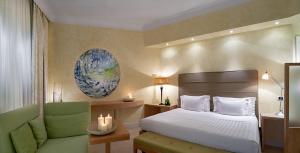 una camera con letto e sedia verde di Tombolo Talasso Resort a Marina di Castagneto Carducci