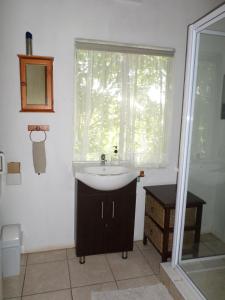 a bathroom with a sink and a window at Geckos B&B and Self-catering in Coffee Bay