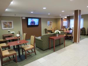 a waiting room with a couch and tables and a tv at Microtel Inn & Suites Dover by Wyndham in Dover