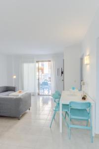 a living room with a table and chairs and a couch at Apartamentos Lago in Colonia Sant Jordi