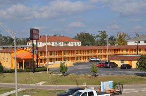 a hotel with cars parked in a parking lot at Travel Inn Beaumont in Beaumont