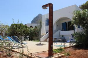 a view of a building with a pool and chairs at Villa Casa Madre in San Vito lo Capo