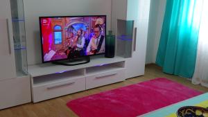 a living room with a tv on a white entertainment center at Apartments - IRINA in Sveti Stefan