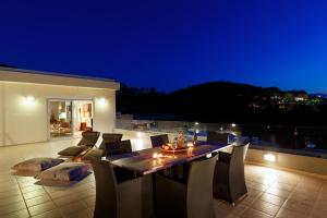 een eettafel en stoelen op een balkon in de nacht bij Stelios Penthouse in Rethimnon