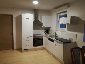 a kitchen with white cabinets and a stove top oven at Alpenrose in Silandro