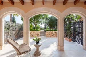 an outdoor patio with two chairs and a vase with flowers at Son Julia Country House & Spa in Llucmajor