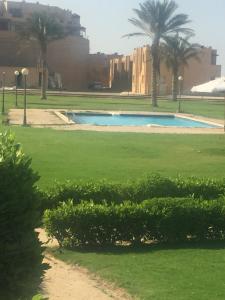a swimming pool in a park with palm trees at Beach Front Chalet (For Families) in Ain Sokhna