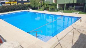 a large swimming pool with blue water at ROMA XII - Apartamento Familiar in Playa de Gandia