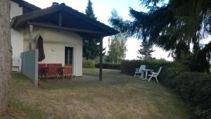 a house with a table and chairs in the yard at Blick in die Südeifel in Biersdorf am See