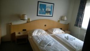 a bed in a bedroom with two night stands and two lamps at Blick in die Südeifel in Biersdorf am See