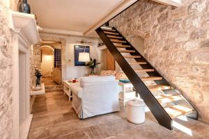 a living room with a staircase and a stone wall at Villa Varda - Villa Latica in Hvar