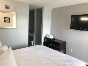 a bedroom with a bed and a flat screen tv at Apple Valley Inn Pigeon Forge in Pigeon Forge