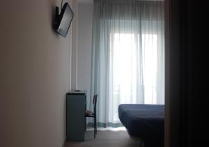 a bedroom with a bed and a window at Hotel Caravelle in Riccione