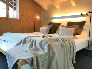 ein Schlafzimmer mit 2 Betten mit weißer Bettwäsche und Blumen darauf in der Unterkunft Chalet ELK Lenk in Lenk im Simmental