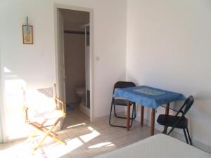 a room with a table and chairs and a toilet at L'oiseliere in Sainte-Marie-de-Ré