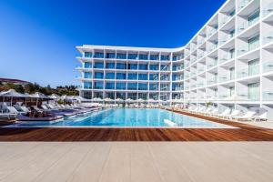 a large building with a swimming pool in front of it at Eleana Hotel in Ayia Napa