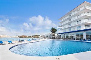 a swimming pool in front of a hotel at azuLine Hoteles Mar Amantis & II in San Antonio Bay