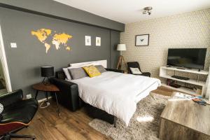 a bedroom with a large bed and a tv at Modern Central Family-Home for 6 in London