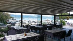 a restaurant with tables and chairs and a view of the ocean at Villa Domic in Slatine