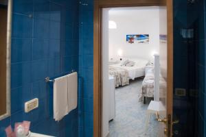 Baño con dormitorio con cama y espejo en Hotel San Giovanni, en Polignano a Mare