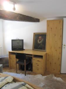 Zimmer mit einem Schreibtisch und einem TV darüber. in der Unterkunft Haus Tradition Monschau 2 in Monschau