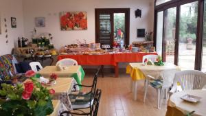Agrisicilia (Relax Mare e Natura) في مارينيلا دي سيلينونتي: غرفة طعام مع طاولات وكراسي عليها طعام +63 صورة