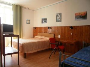 Dormitorio con cama, escritorio y TV en Hôtel Modern en Concarneau