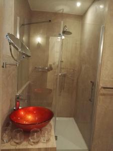 a bathroom with a shower with a red bowl at Vallettastay Casa Zoe in Valletta
