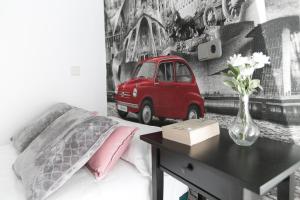 1 dormitorio con 1 cama y un jarrón de flores sobre una mesa en Hostal La Bañezana, en Madrid