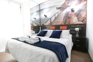 a bedroom with a large bed and a large window at Hostal La Bañezana in Madrid