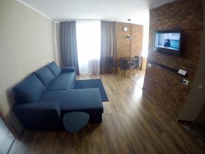 a living room with a blue couch and a tv at Apartment in the center in Chernihiv