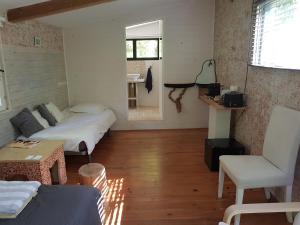 サントロペにあるMaison d'Hôtes Le Calmeのベッド2台、ソファ、テーブルが備わる客室です。