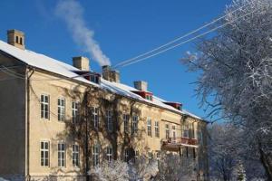um edifício velho com fumo a sair dele em Lindsbergs Kursgard and hostel em Falun