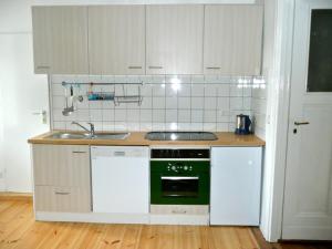 cocina con armarios blancos y horno verde en City Apartment Berlin, en Berlín